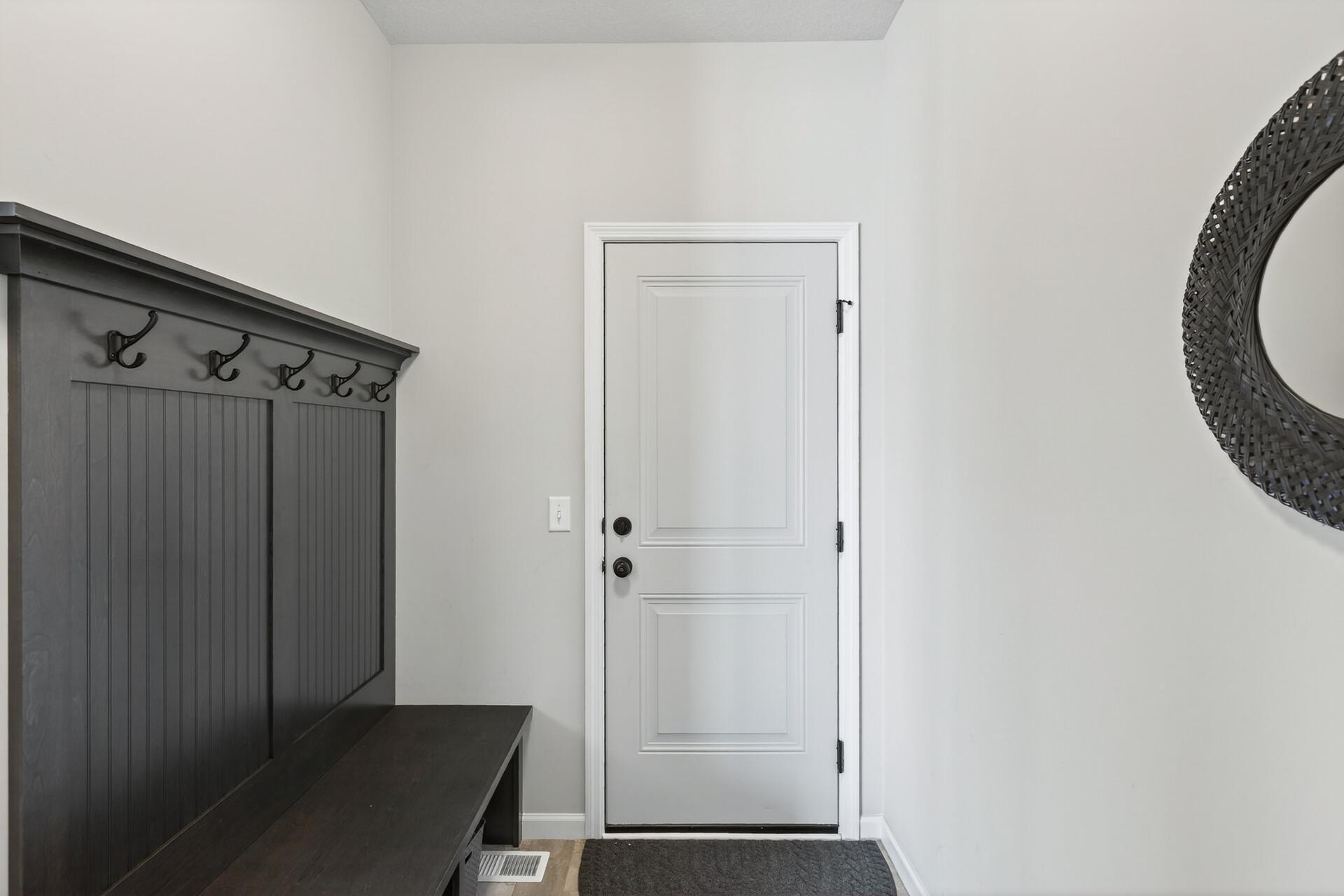 Mudroom off the kitchen with a custom shoe bench that leads to the garage.