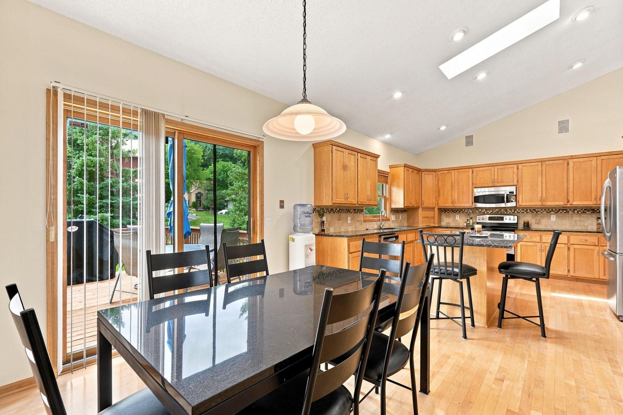 The informal dining area opens to the expansive deck and a natural gathering space