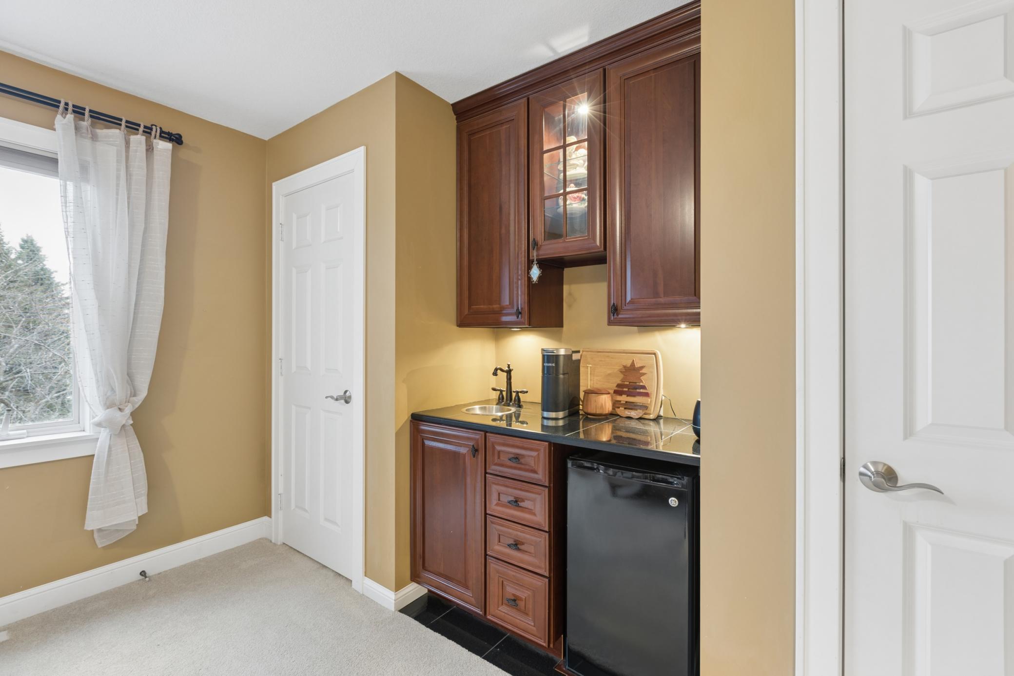 View of the dual closets that flank either side of the coffee bar with sink and built-in minifridge.