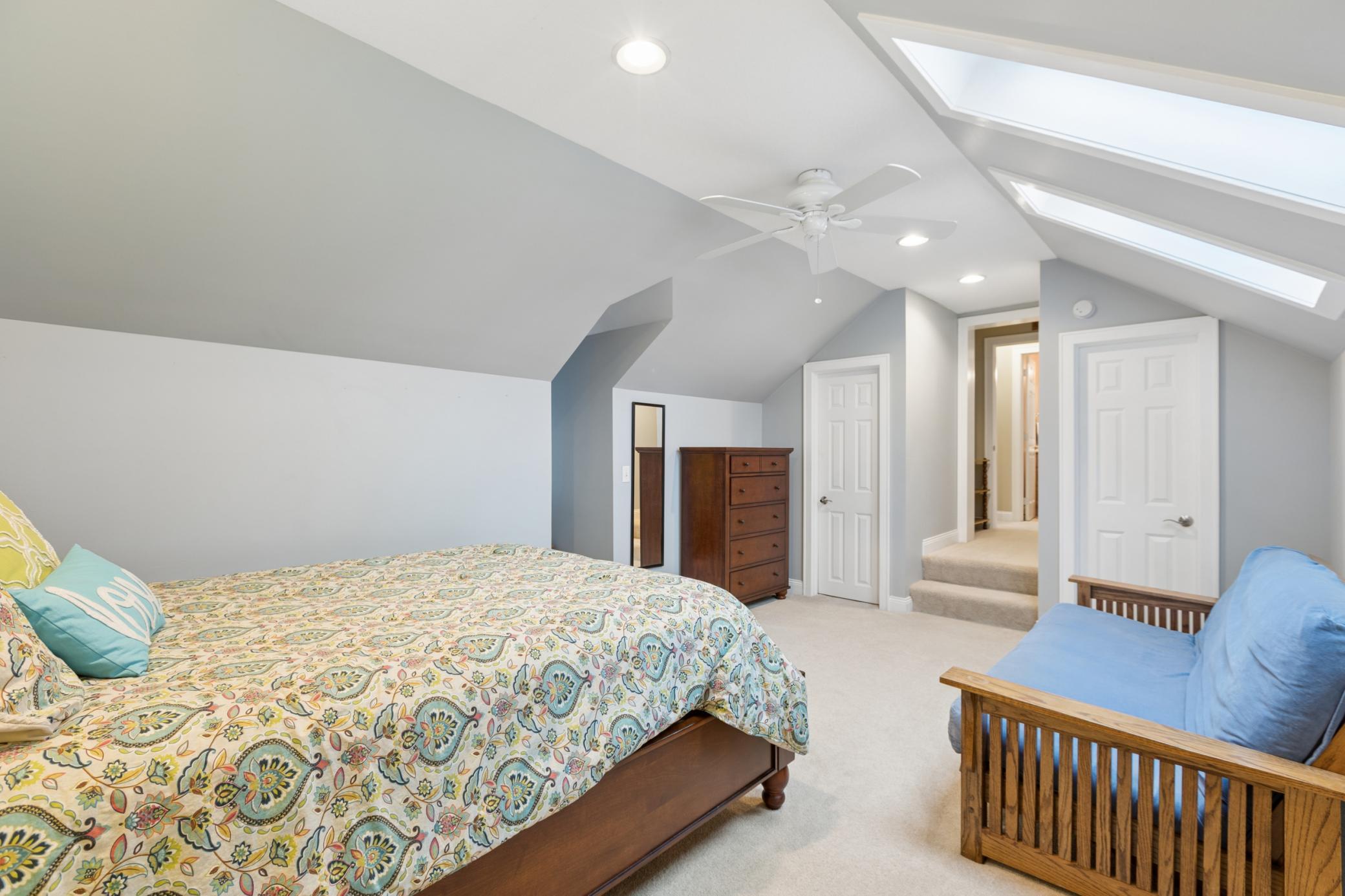 View of the second of four bedrooms on the upper level of the home. This with plenty of storage. Skylights were replaced in 2022.