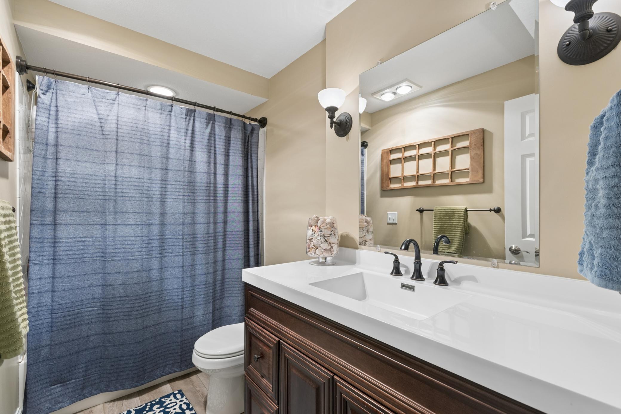 View of the lower-level full bathroom. This home is ready for its new owners to enjoy with number of mechanical and exterior updates done in recent years including the water heater, carpeting, roof, garage doors, kitchen appliances and skylights.