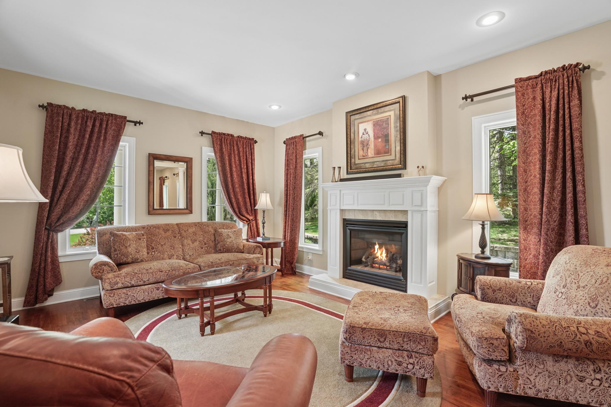 View of the den that is just off the entryway, a perfect place to enjoy a book by the fireplace.
