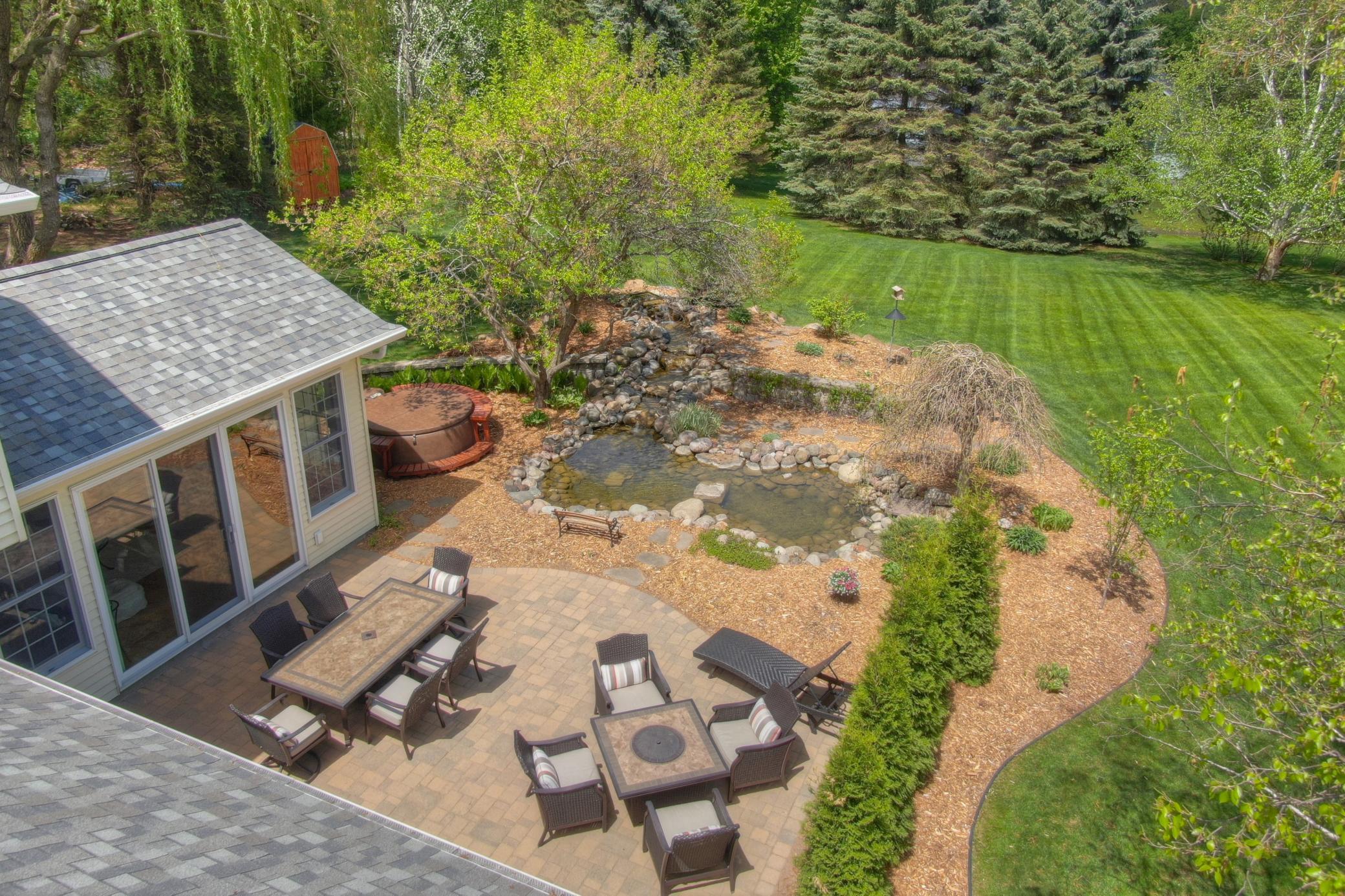 Just off the sunroom is a spacious paver patio that is surrounded by perennial gardens and backs up to a koi pond with waterfall feature. From entertaining to relaxing this versatile space is perfect for enjoying the natural beauty that surrounds it.