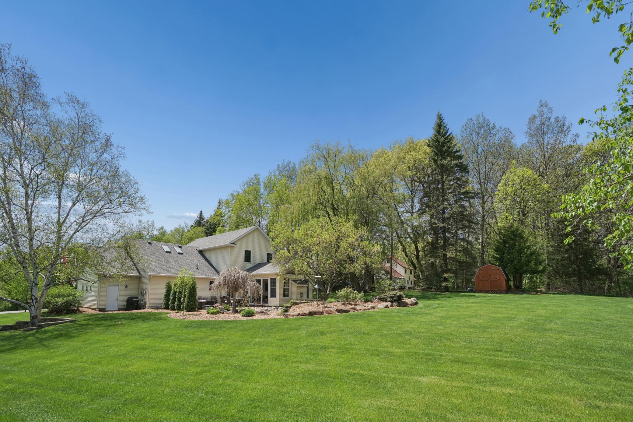 View of the expansive back yard that is flat and usable space and everything here can be mowed with a riding lawn mower for easy maintenance.