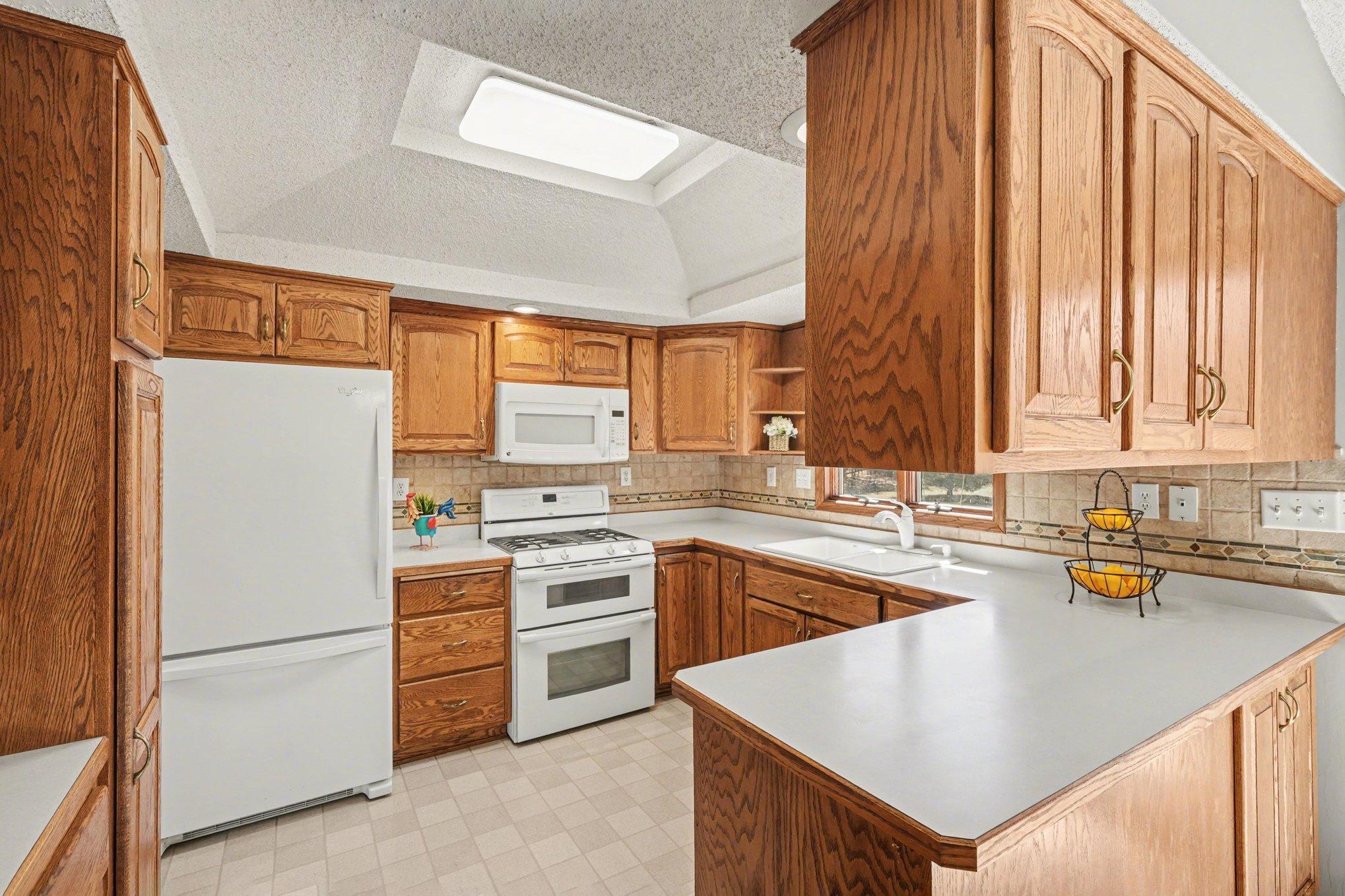 This kitchen brims with/ natural light and joy! Tons of storage and even a display shelving unit on the left.
