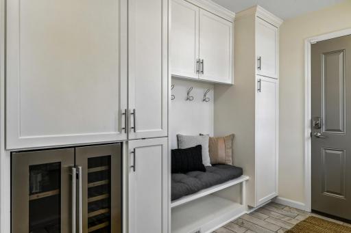 Hard to find mud room with heated tile flooring, custom built-ins, bench seat, beverage fridge and access to the deck and heated garage.