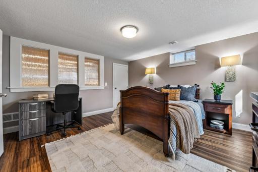 Bedroom 4 is located on the lower. It features LVP flooring, two closets, sconce & overhead lighting and large egress window.