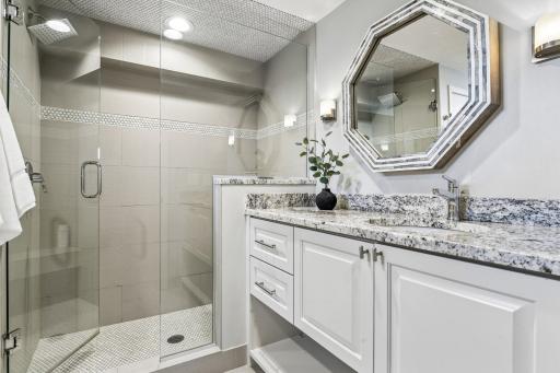 Nicely updated, the lower level 3/4 bath features tile finishes and a raised vanity with granite counter and framed mirrror.