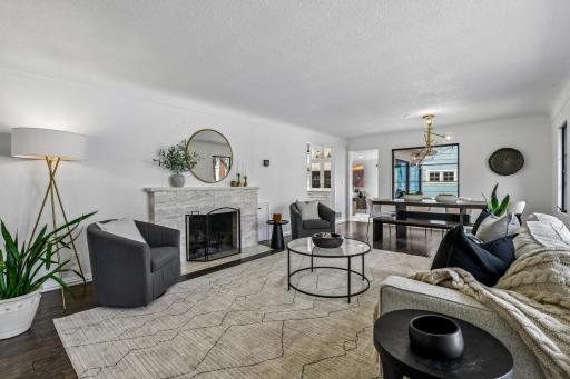 The living room features coved ceiling, an oversized window, wood floors, wood-burning fireplace and a built-in with drawer storage.
