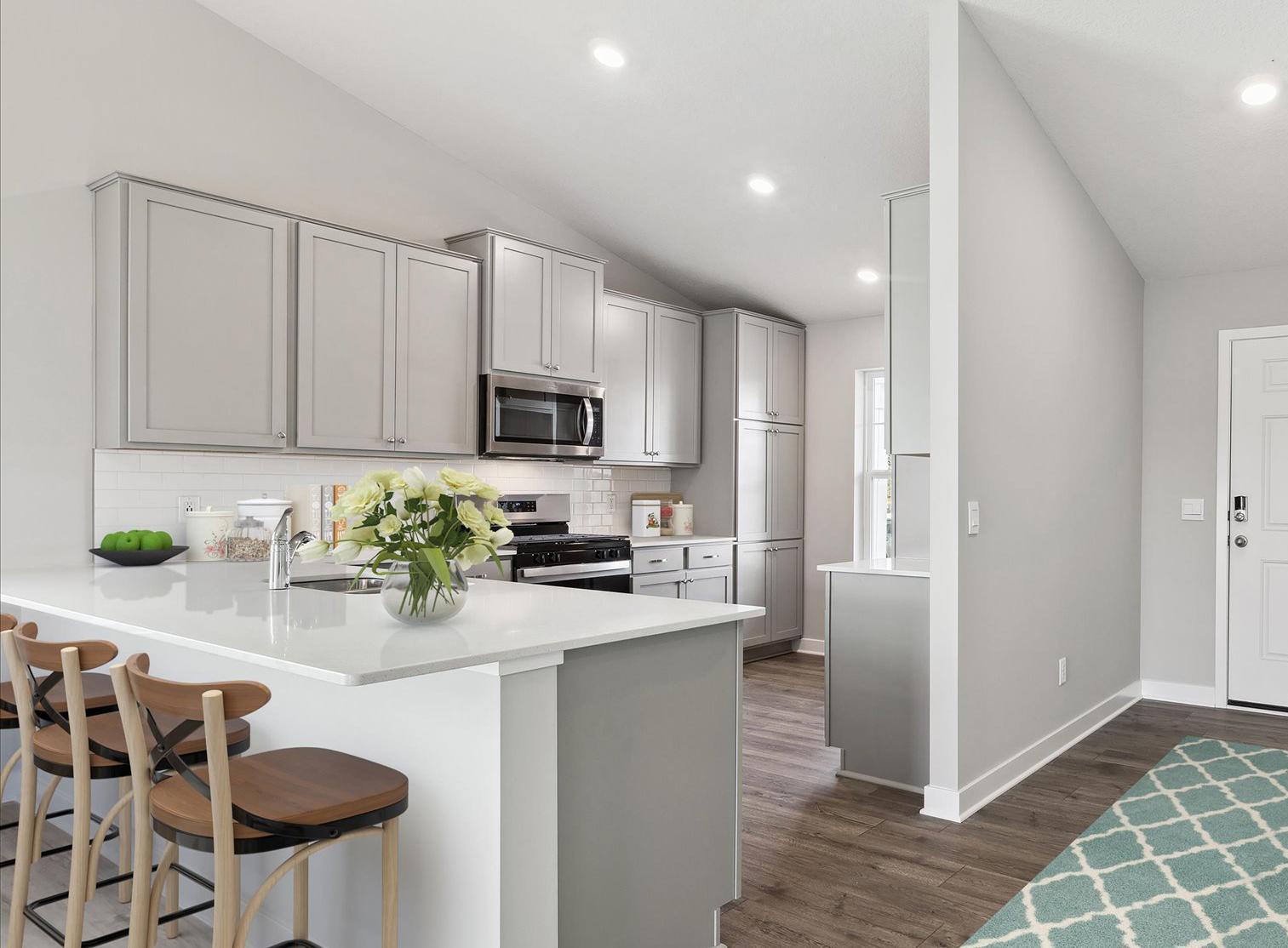 Kitchen featuring quartz countertop and large breakfast peninsula is a great place for daily meals and conversation. *Picture of model home; actual finishes may vary.