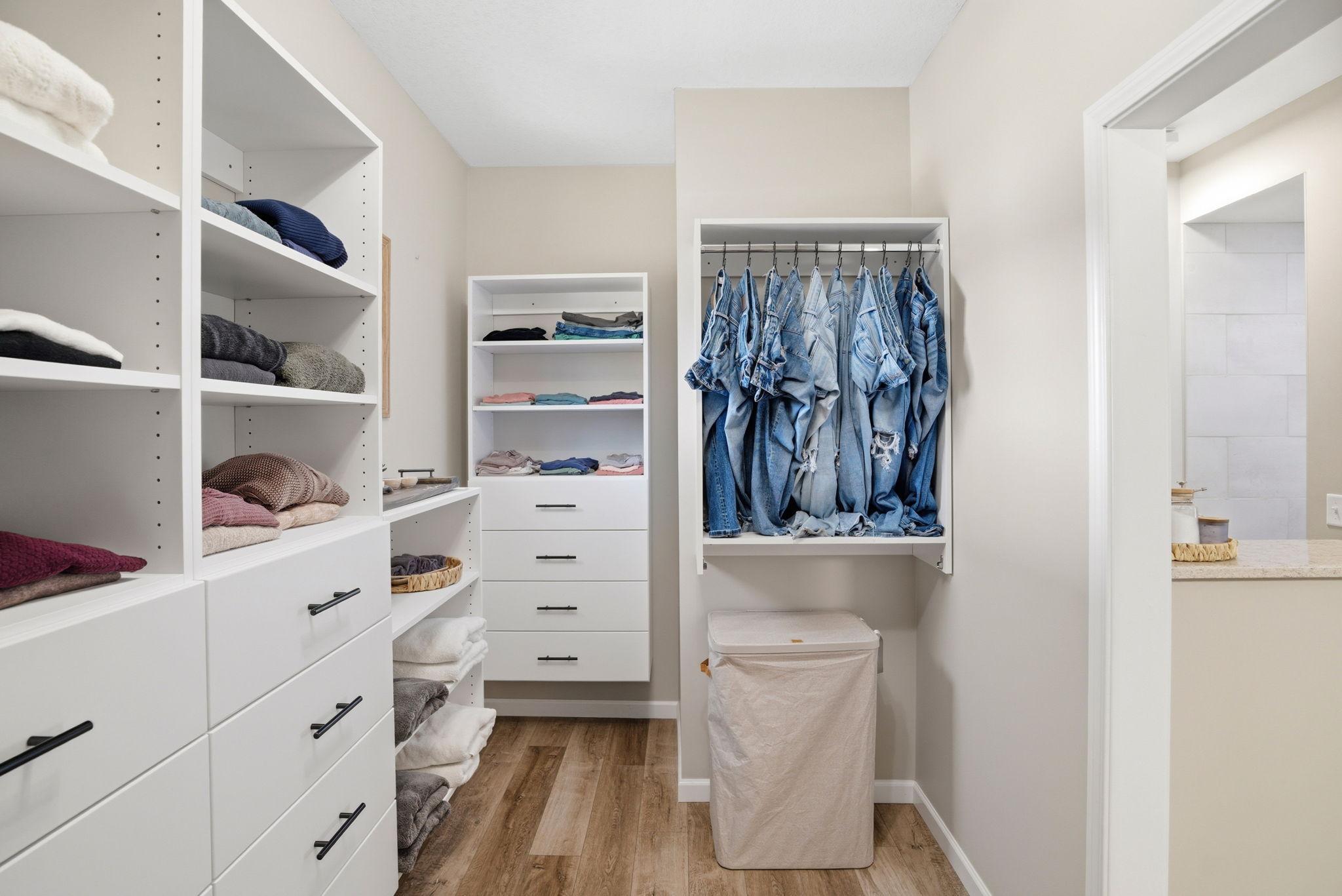 Luxurious dream closet featuring an ideal combination of hanging areas, open shelving, and custom drawers.