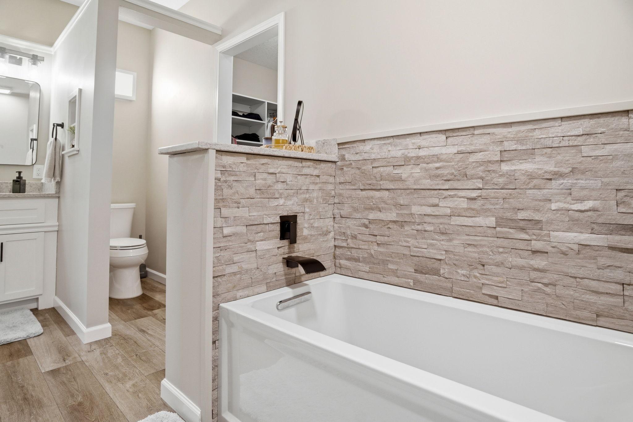 Relaxing soaking tub framed by a stunning tile surround. Walk in shower is located directly behind!