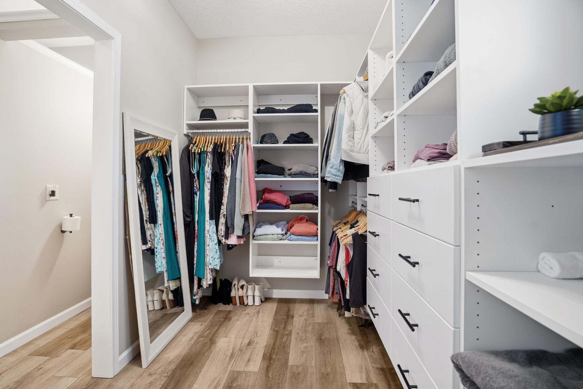 Luxurious dream closet featuring an ideal combination of hanging areas, open shelving, and custom drawers.