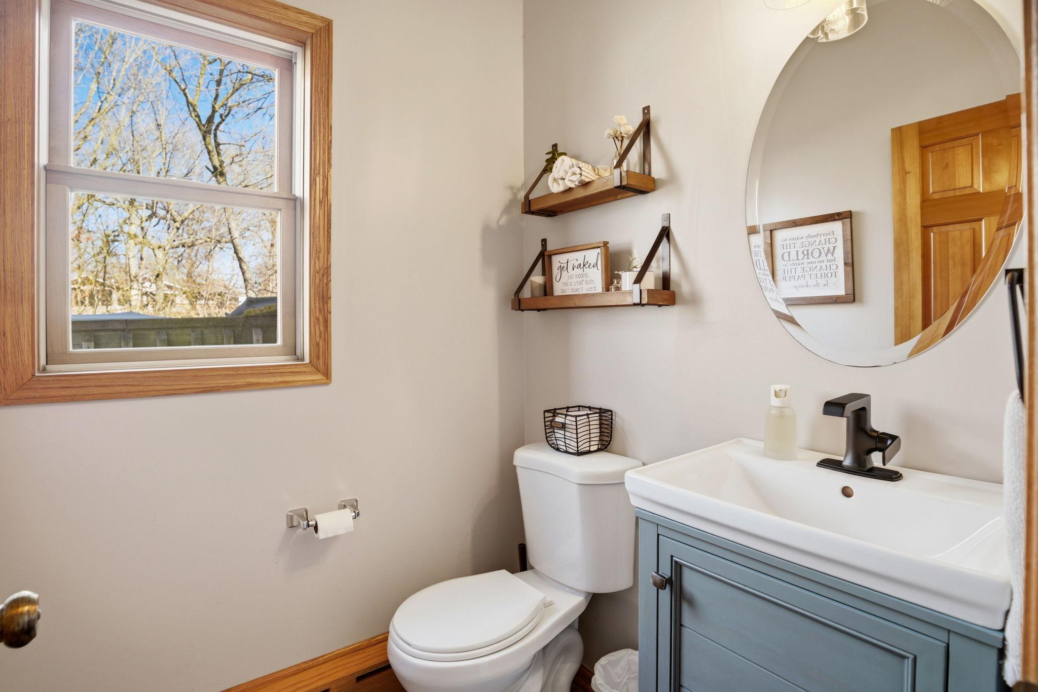 Convenient half bath located off the dining room, featuring an updated toilet and sink