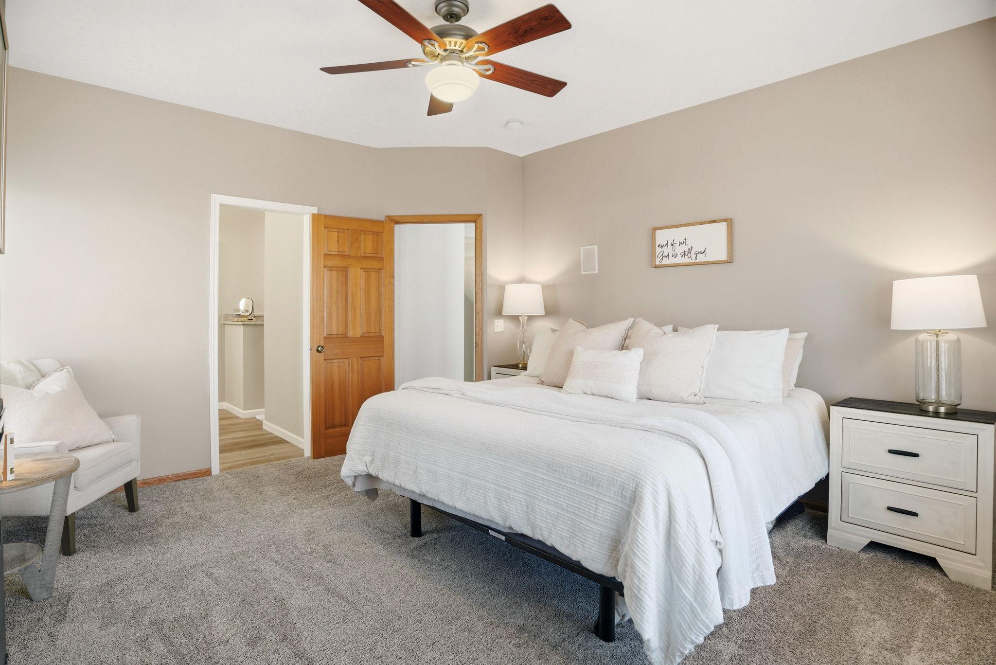 Main-level primary bedroom offers generous space, a charming electric fireplace, and tranquil views overlooking the wooded backyard. Sneak peak into the newly remodeled primary bath and closet!