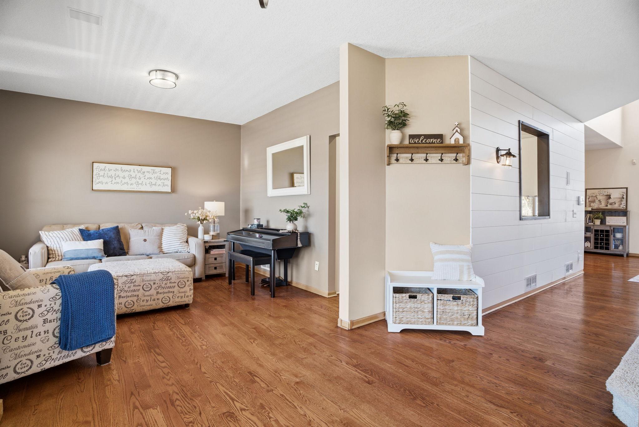 Refinished hardwood floors add elegance, complemented by knockdown ceilings and a shiplap accent wall.
