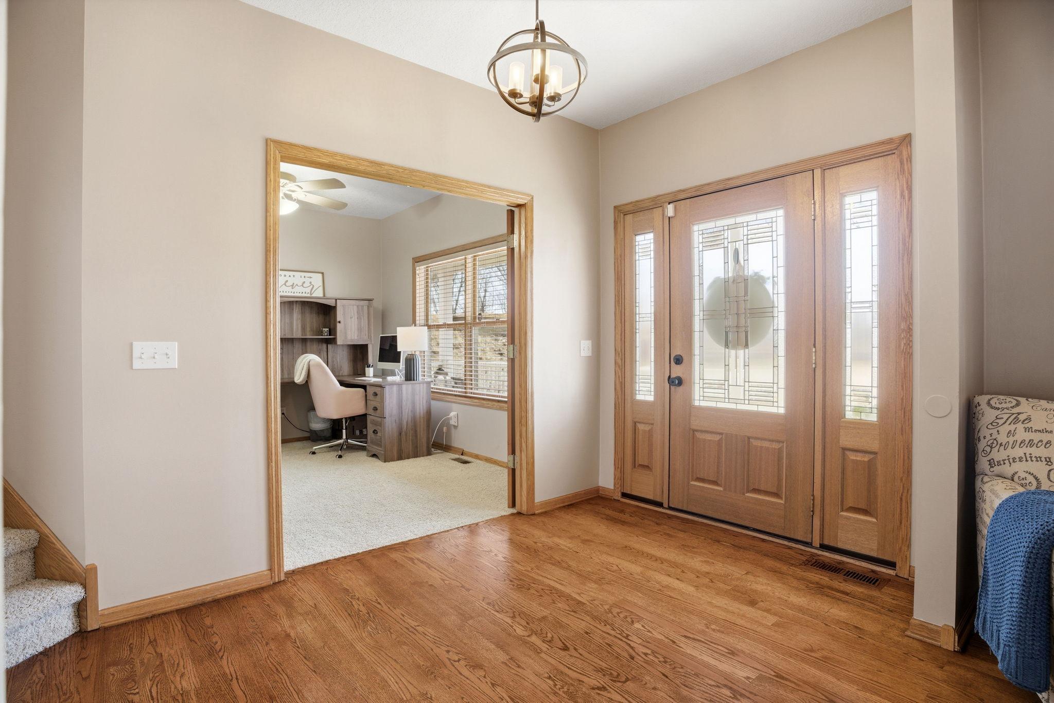 Inviting foyer featuring beautiful wood floors and a charming view of the front office.