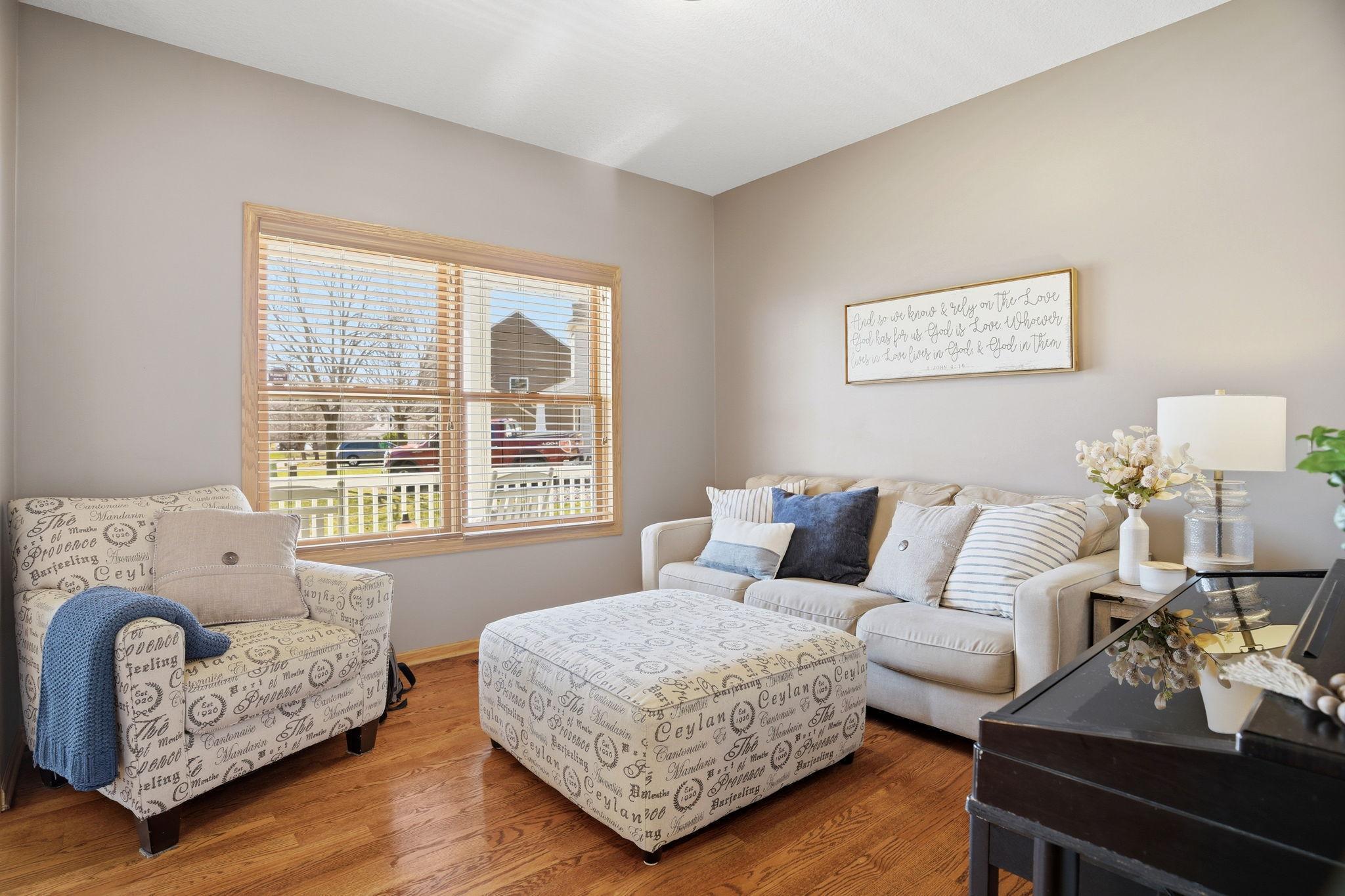Living room located just off the foyer, facing the front of the home, featuring beautiful wood floors and abundant natural light.