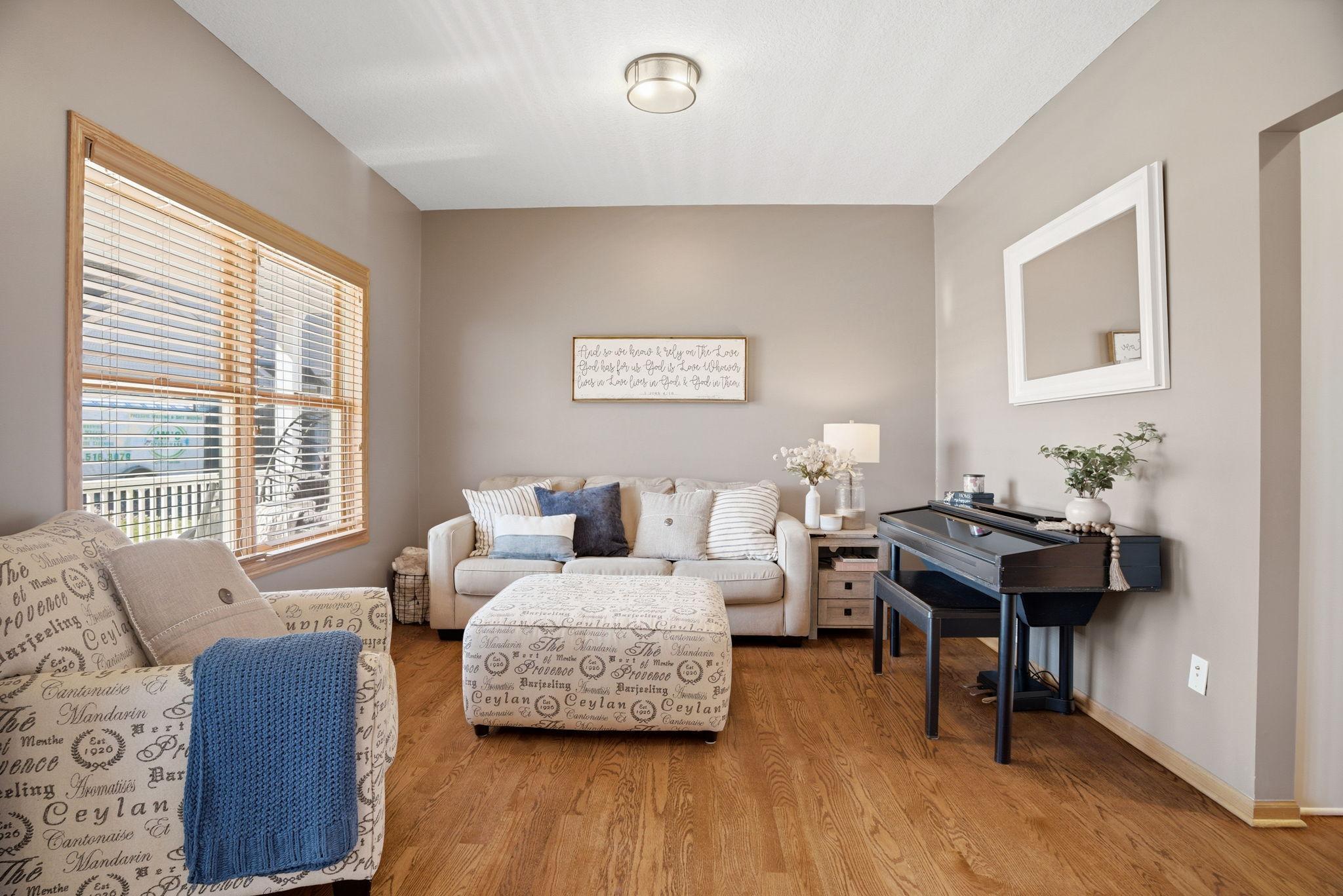 Living room located just off the foyer, facing the front of the home, featuring beautiful wood floors and abundant natural light.