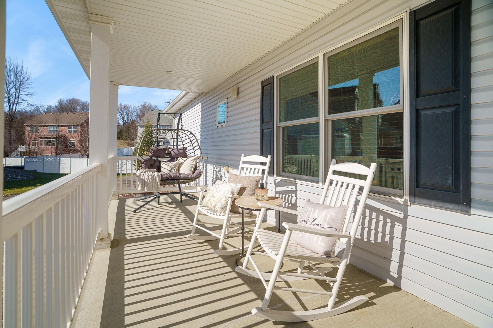 Expansive front porch stretching across the entire front of the home, adding charm and functional outdoor living space.