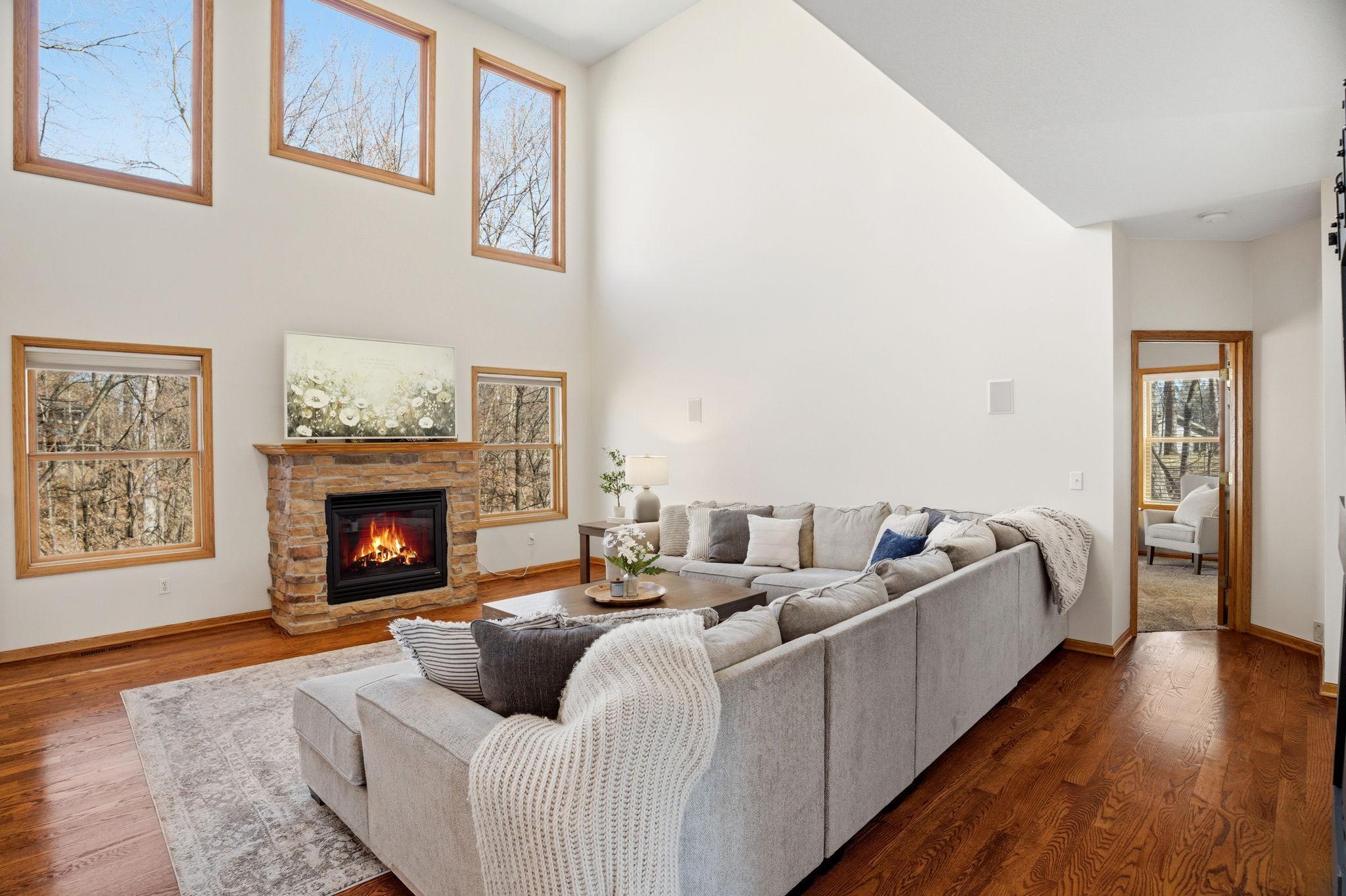 Expansive great room with a statement windows, gas fireplace and picturesque views of the wooded backyard. Just on the other side is the primary main floor bedroom.