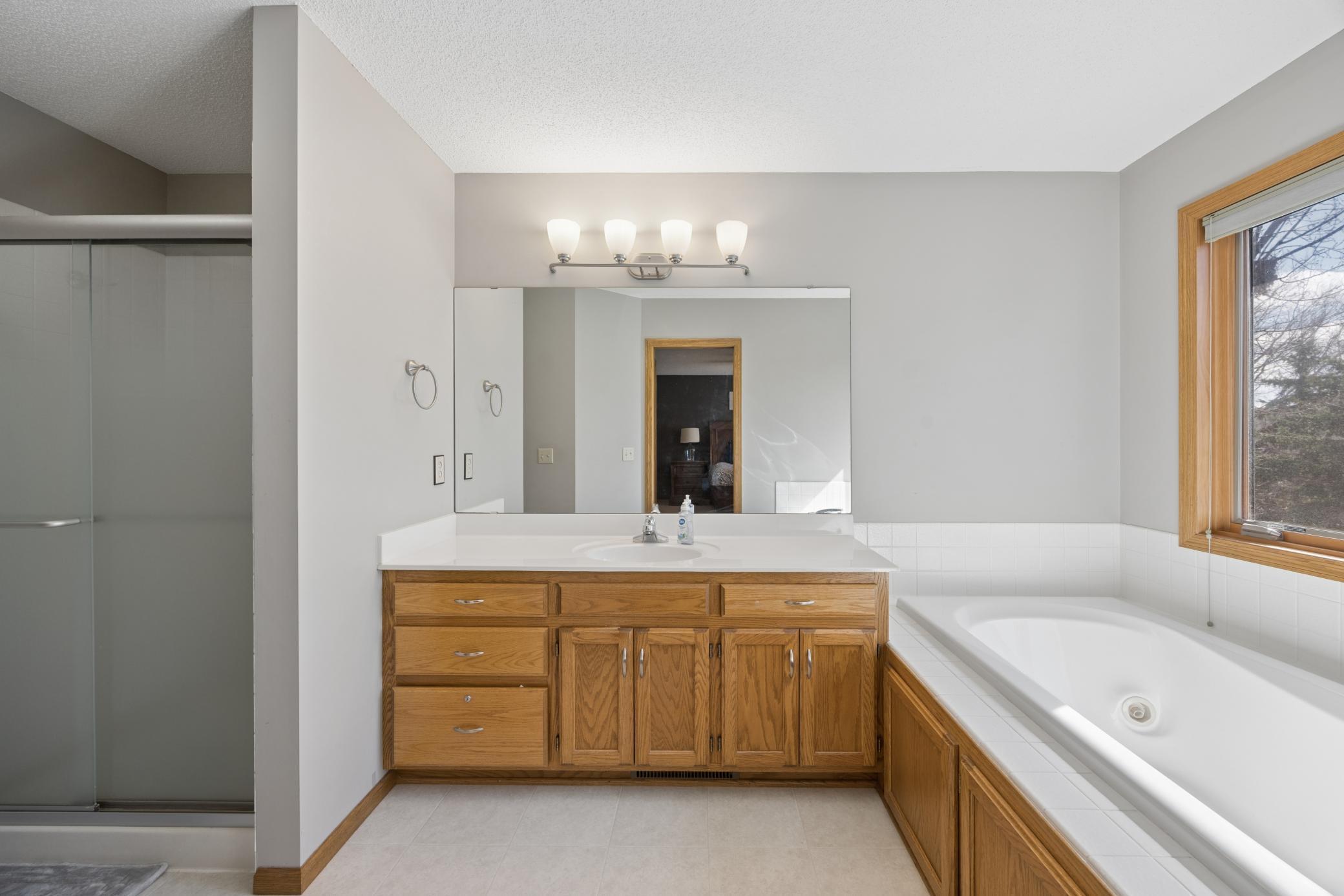 Full private primary bathroom with separate shower and jetted tub