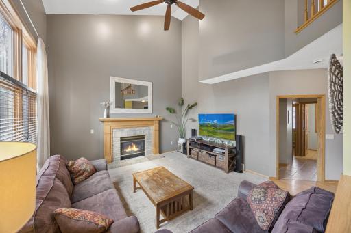 Additional view of two story living room with ceiling fan