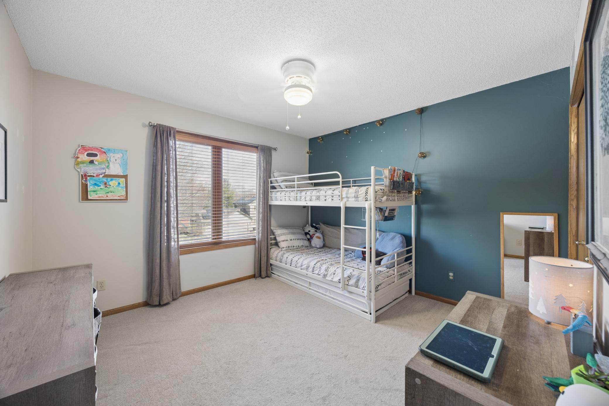 Second of three bedroom upstairs has custom built shelving in the closet