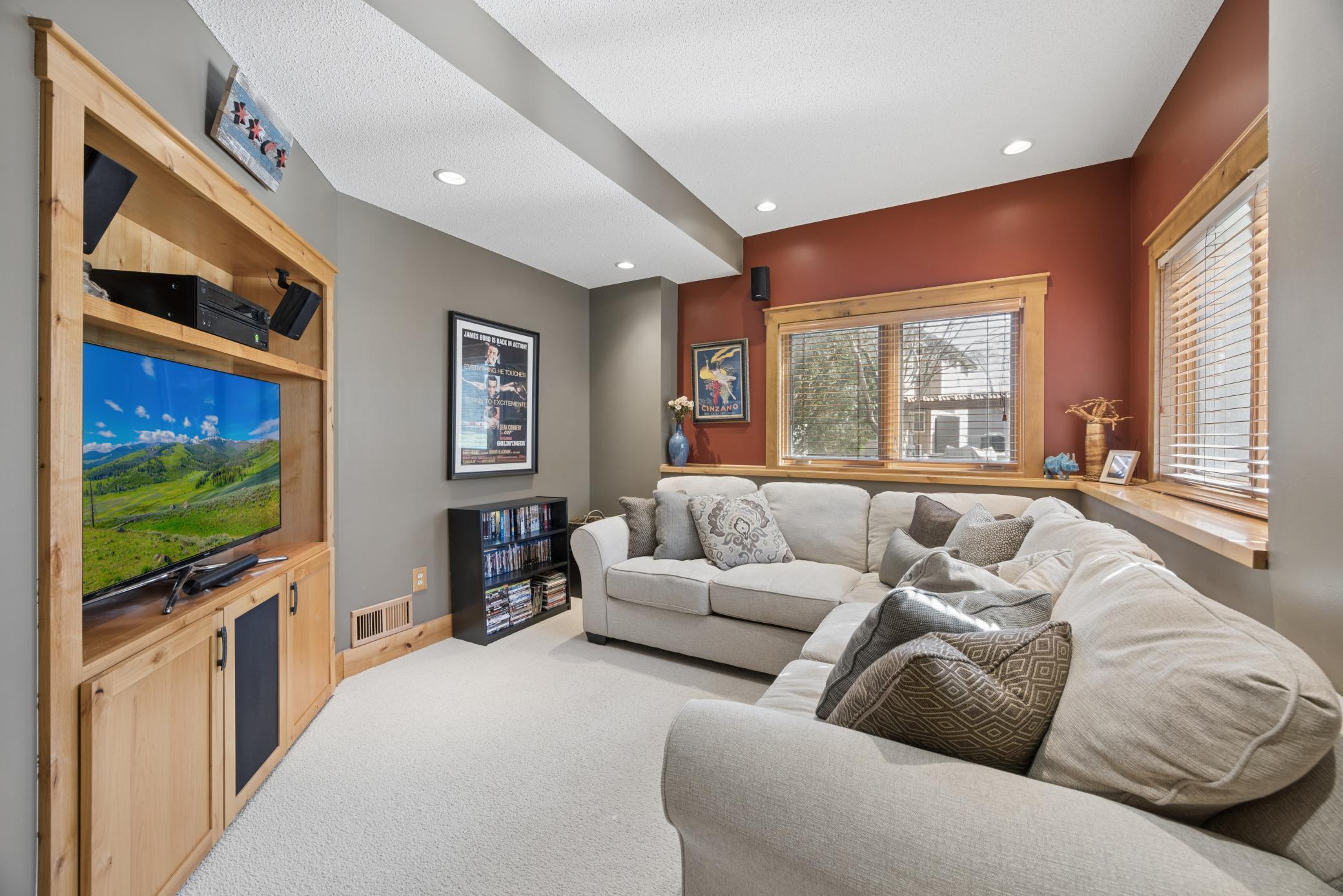 Lower level family room with built in entertainment center and speakers is a cozy little place to curl up and watch a good movie.