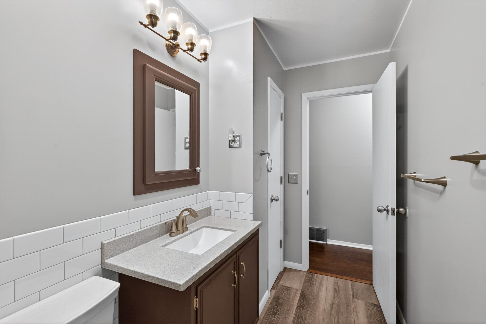 The bathroom has been recently updated with a new vanity and a subway tile tub and shower surround, giving it a fresh, updated feel.