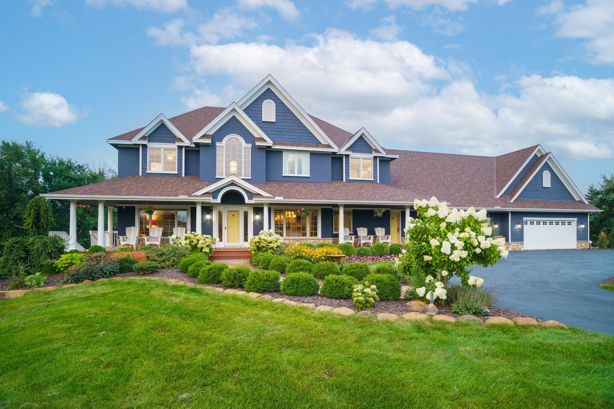 A picture-perfect home featuring a welcoming wraparound porch, vibrant landscaping, and timeless curb appeal.
