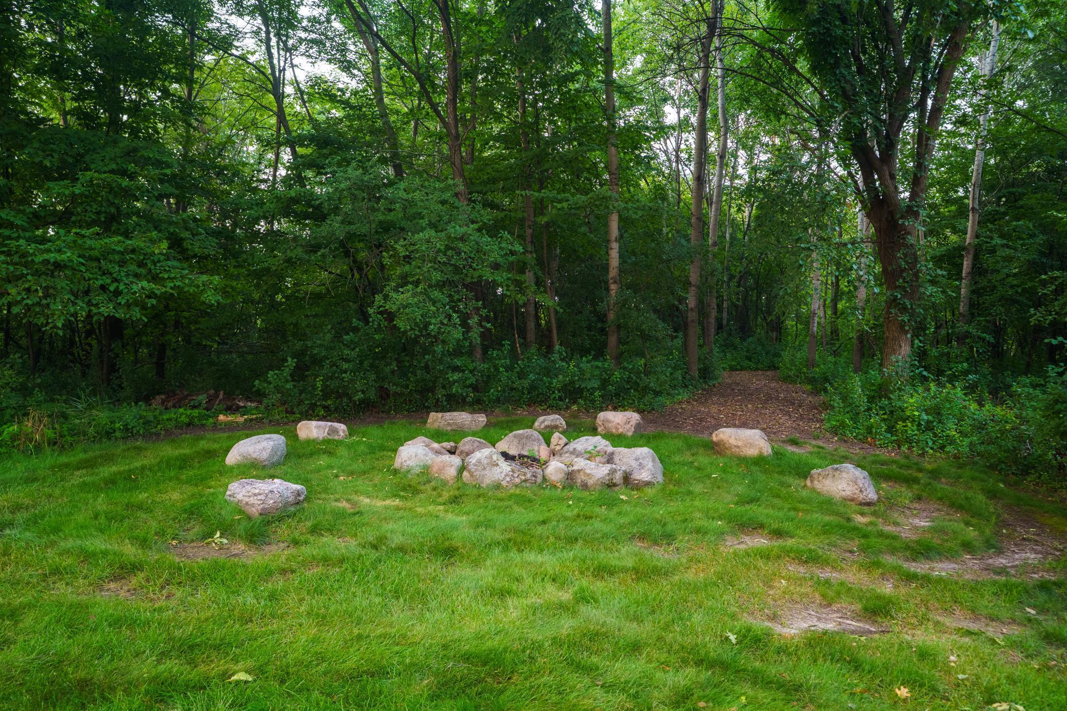 Fire pit and trail access through private woods. Find your way to the knoll - a perfect spot for a future reading clubhouse or a picnic.