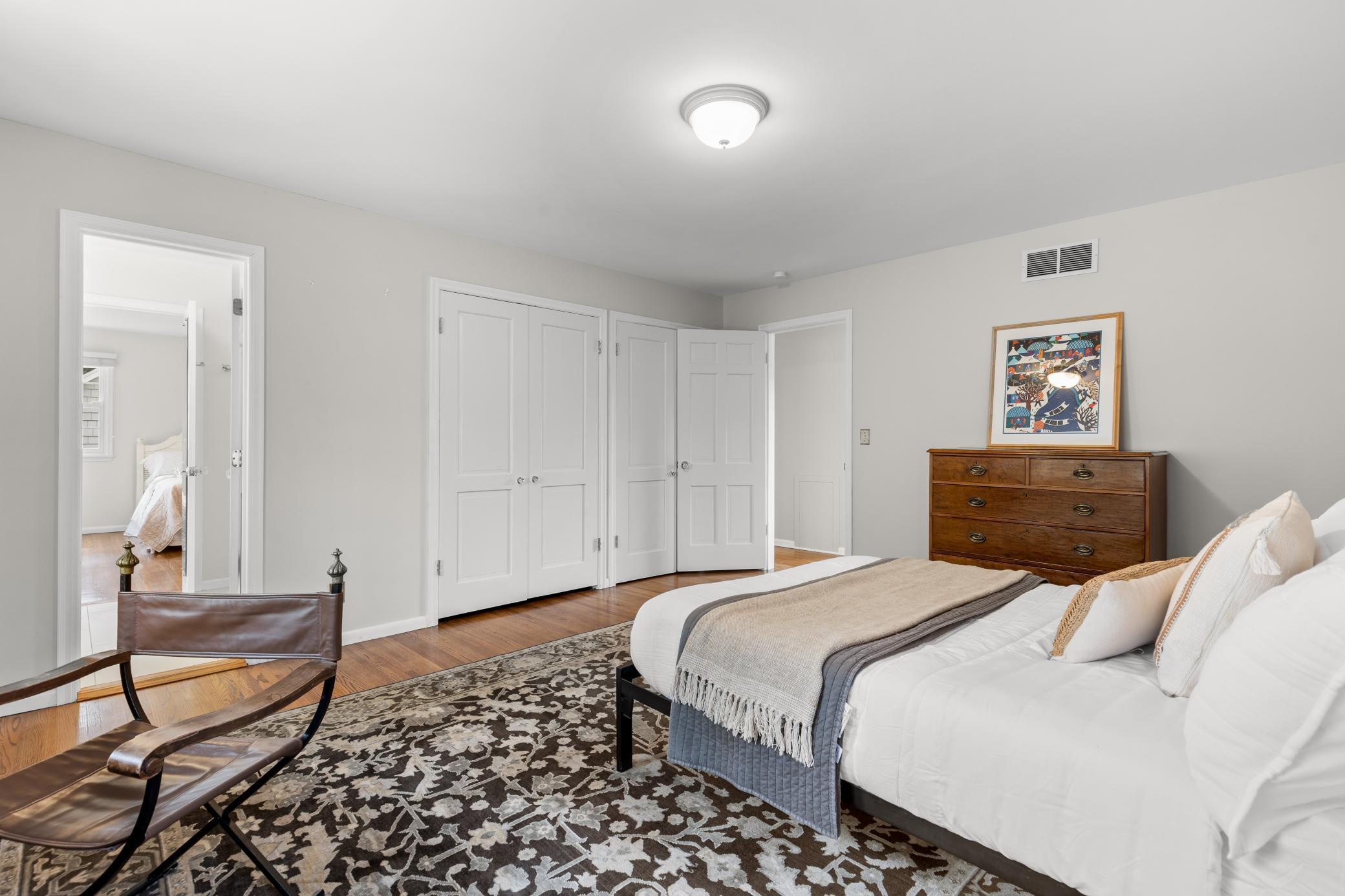 Second level bedroom with hardwood floors and walk-in closets