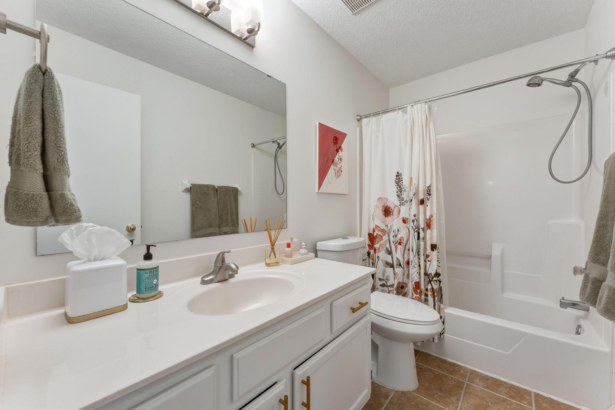 Bright full bath with lots of counter space and storage.