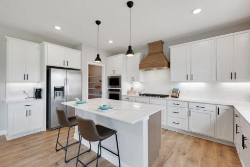 Another view of your gorgeous kitchen featuring high end finishes like quartz countertops, stainless steel appliances, and laminate flooring (Photos of model, options may vary).