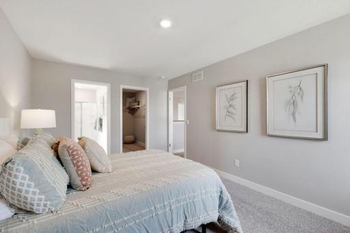 View of the bathroom and walk in closet in bedroom 2. Photos of model, options may vary.