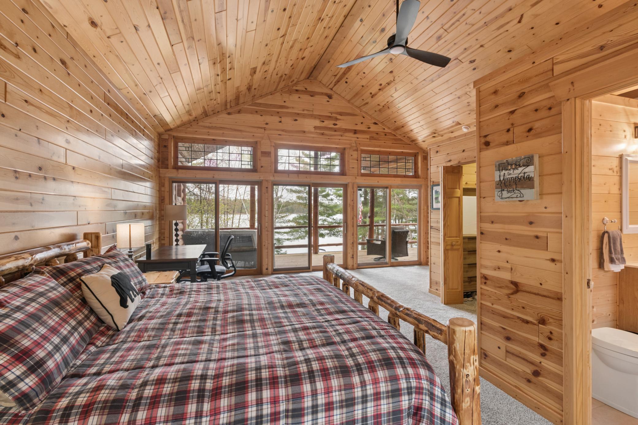 The primary bedroom that is on the main level - HUGE space and it also has access to walk on the deck OR just view the lake!