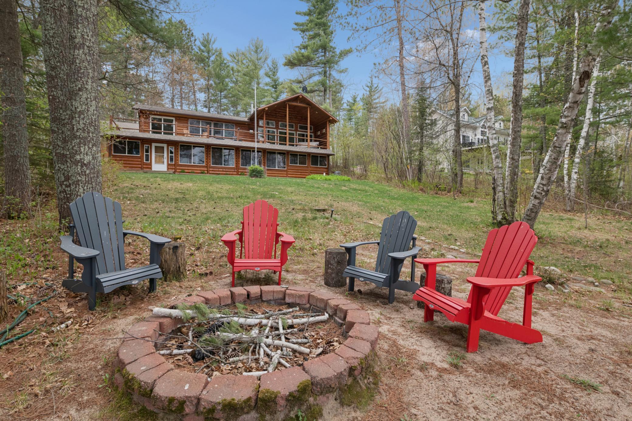 A firepit with the house in the back. Summer s'mores are coming!