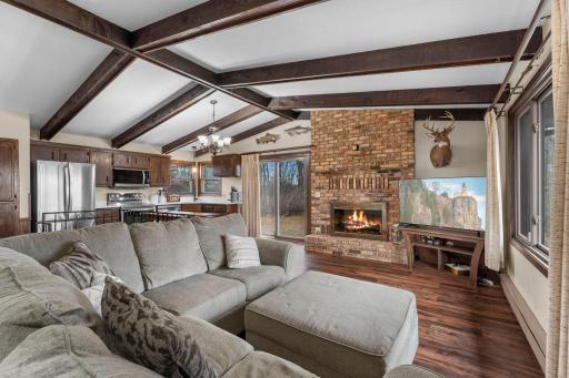 Open floor plan, vaulted and beamed ceiling and a patio door leading to the deck. The entire main level has luxury vinyl plank flooring that was done in 2020.