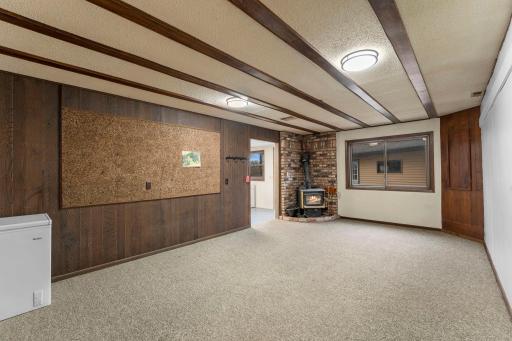 Lower level family room has LED lighting and a wood stove.