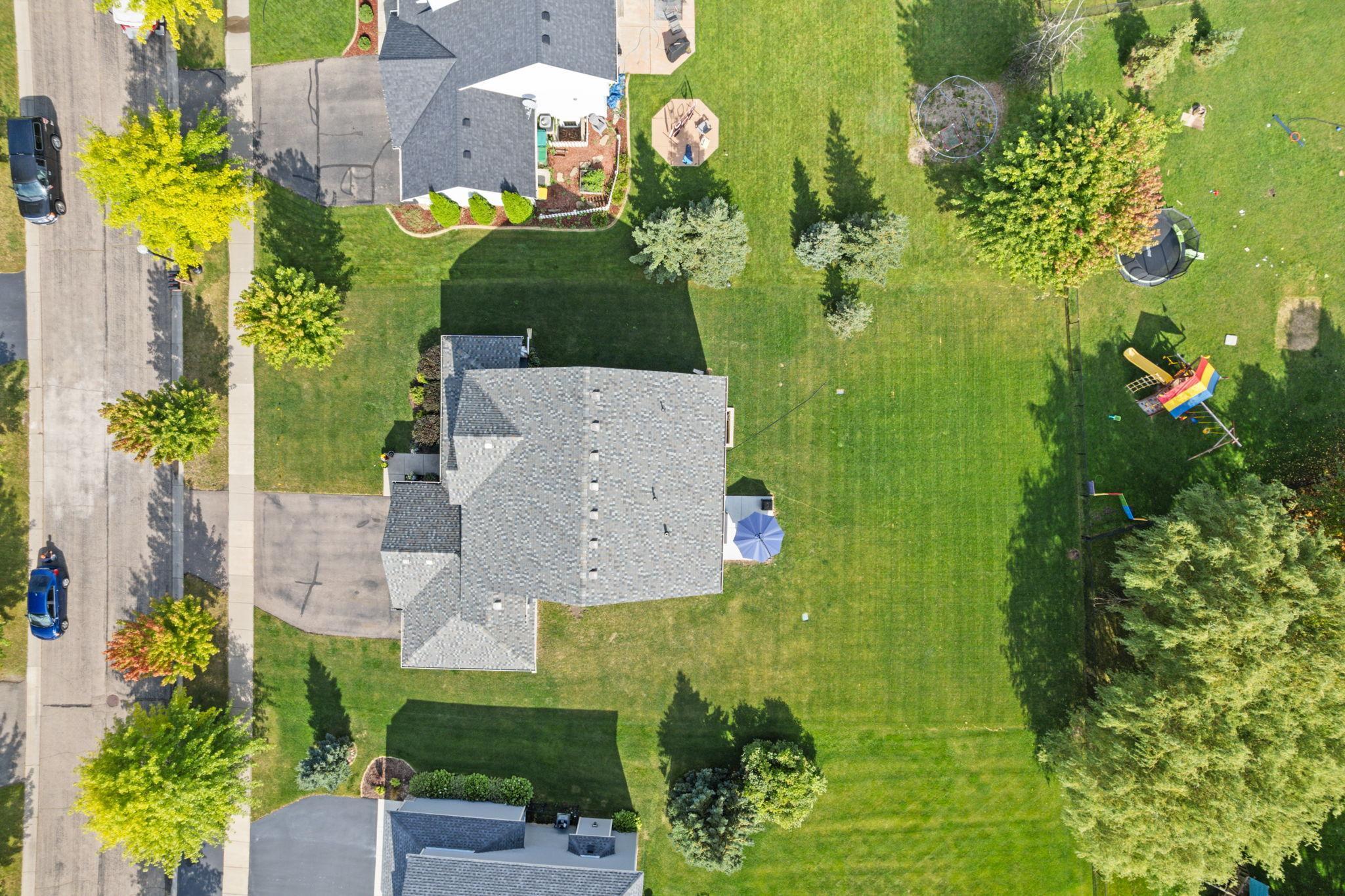 Aerial view showcasing the flat, highly usable .31-acre lot. With a new patio in the backyard and a wraparound porch in the front, the home offers multiple outdoor spaces to enjoy throughout the day.