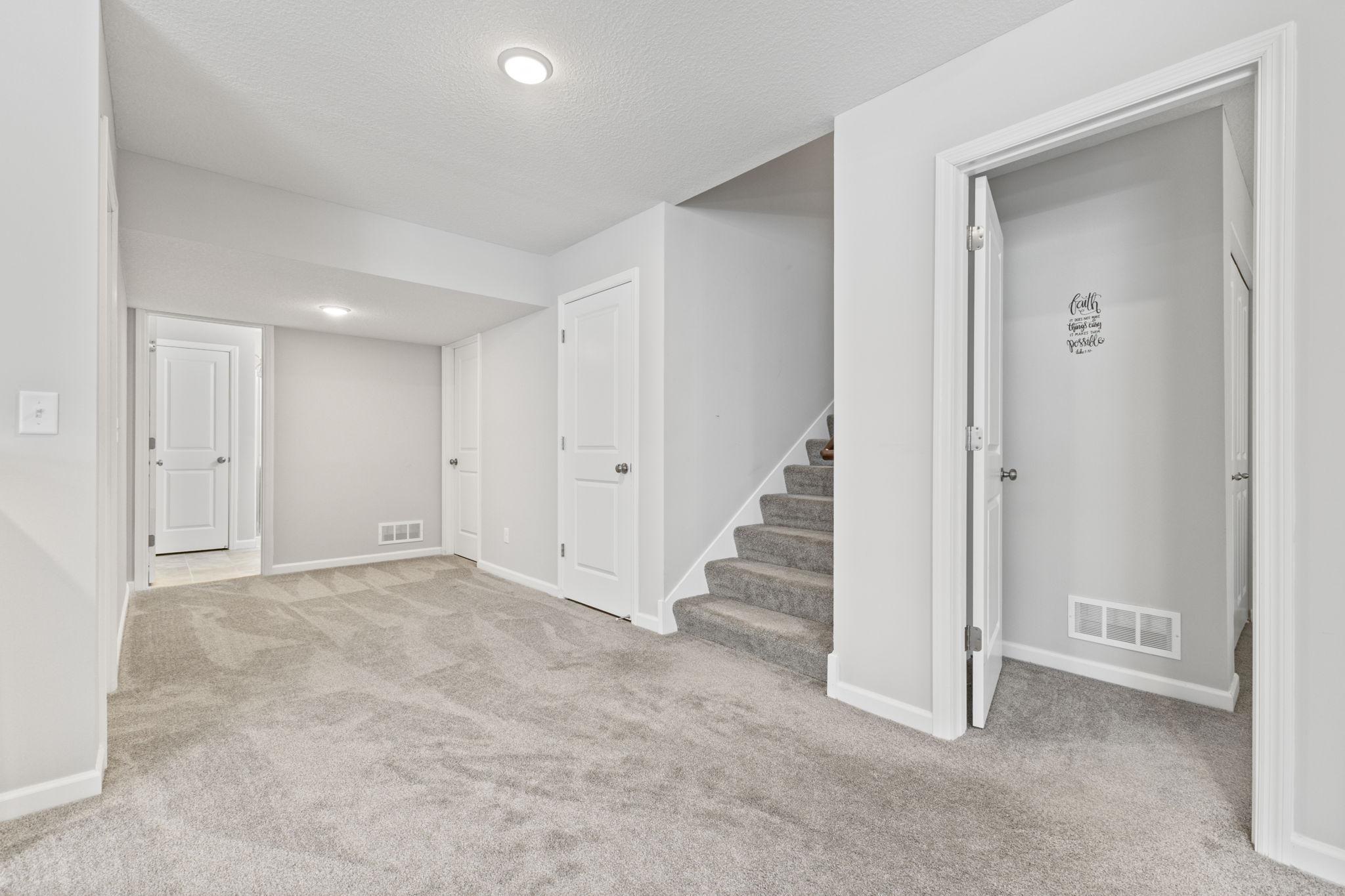 Finished lower level offers a spacious family room with designated entertaining space and bar area, plus a bedroom, den, and 3/4 bath, creating a flexible setup for guests, work, or additional living space.