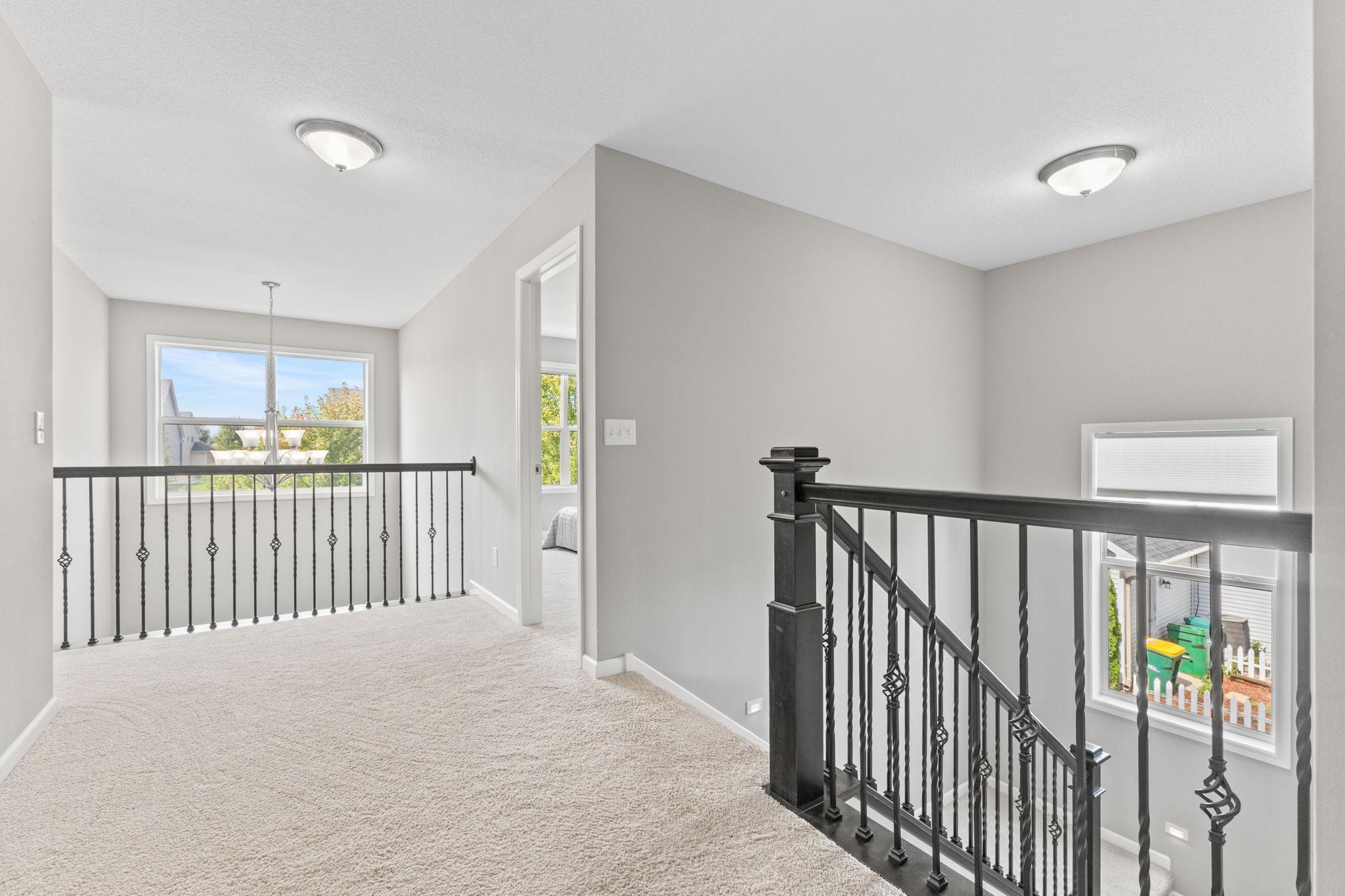 Open second-story landing overlooking the foyer, offering a spacious transition between bedrooms and adding to the home’s light, connected feel.