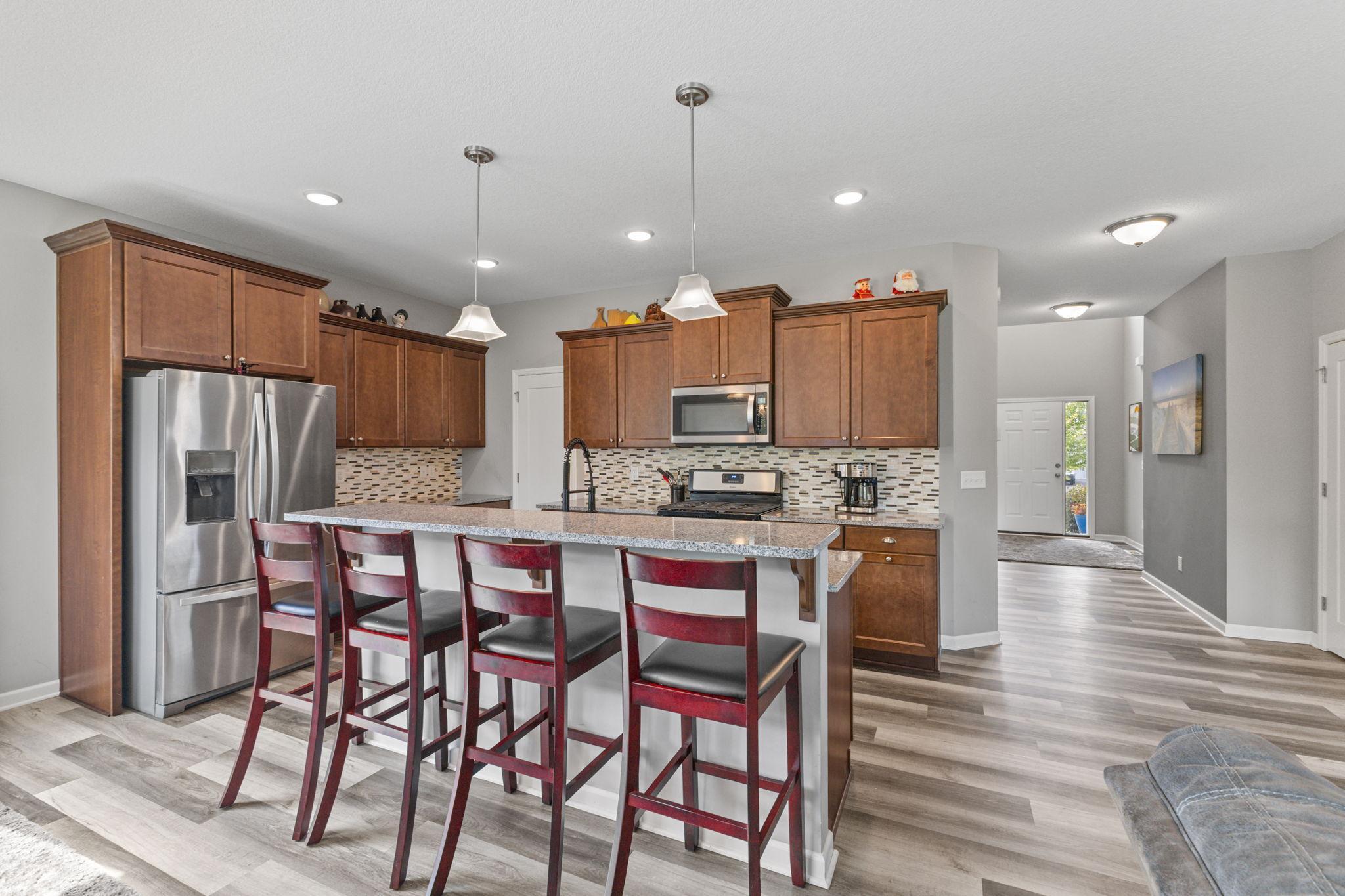 Spacious kitchen with granite countertops, center island seating, and stainless steel appliances. Ample cabinetry and a tiled backsplash add function and style, with an open layout that connects seamlessly to the main living areas.