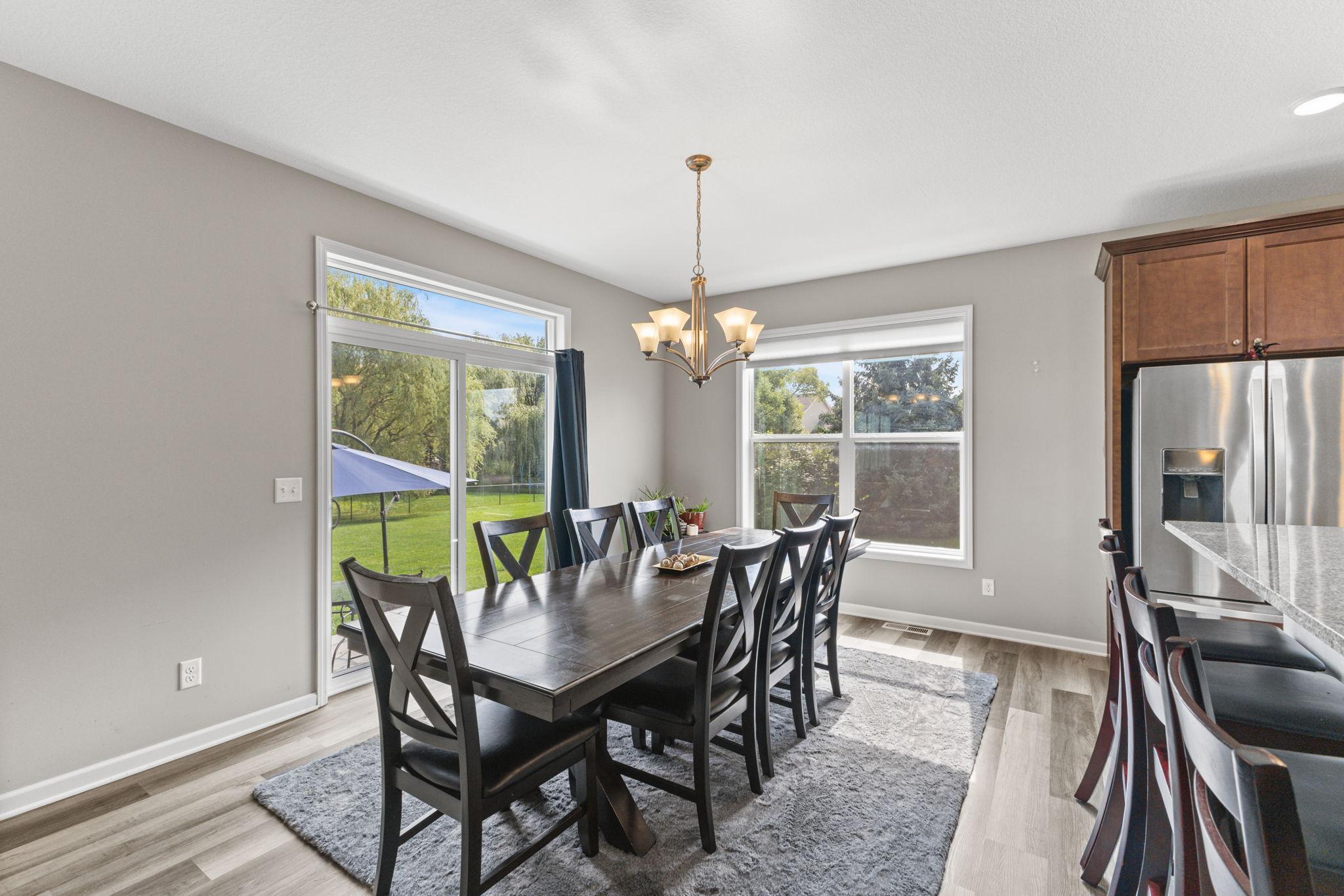 Expansive dining area with space for a large table and additional seating, perfect for hosting. Surrounded by windows and patio access, the layout keeps the space connected while still feeling open and comfortable.