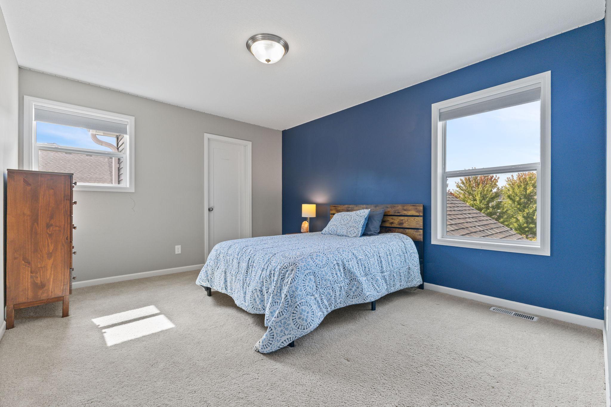 South-facing bedroom with great natural light and a walk-in closet, offering a comfortable layout with plenty of space for furniture and storage.