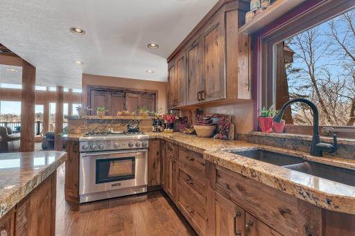 This inviting kitchen features rich wood cabinetry, granite countertops, and a large window that fills the space with natural light.
