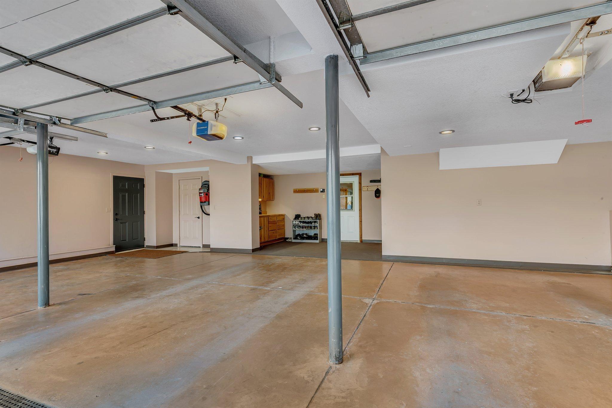 Oversized 3-stall garage with 2 storage rooms and workbench.