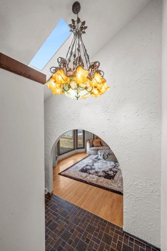 An ornate, old-world chandelier with a Mediterranean/Tuscan feel, featuring scrollwork iron detailing and warm amber glass shades that add character and a dramatic focal point.