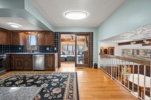 Spacious eat-in kitchen featuring rich wood cabinetry, stainless steel appliances, generous storage, granite counter-tops & hardwood floors. The open layout flows beautifully into the 4-season sun room & family room!!!